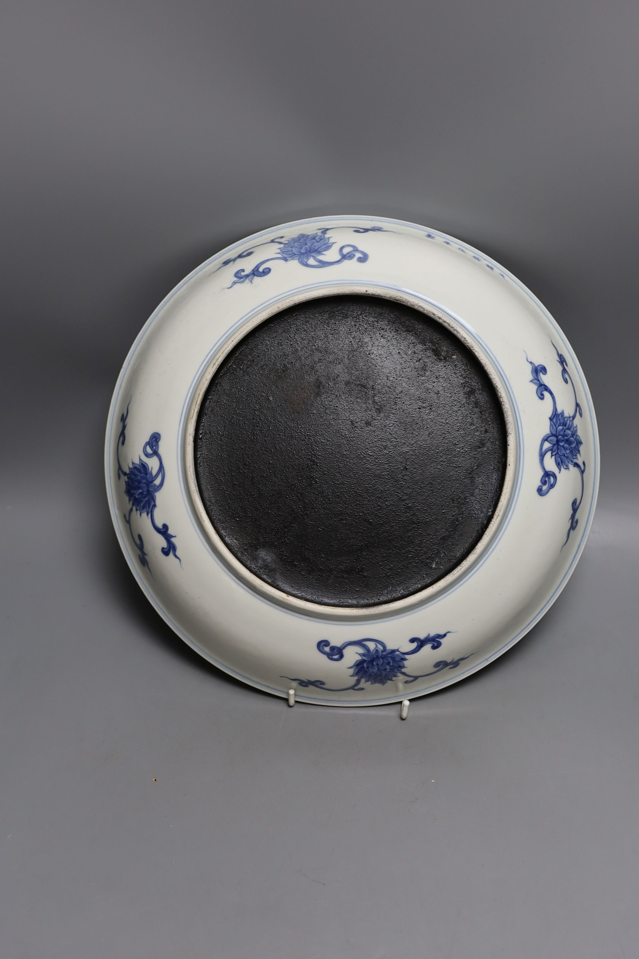 A 19th century Chinese blue and white celadon ground charger, marked to base, together with another blue and white Chinese charger (2)